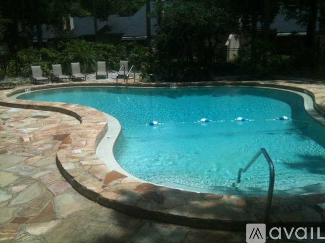 A pool with a stone border and a metal railing.