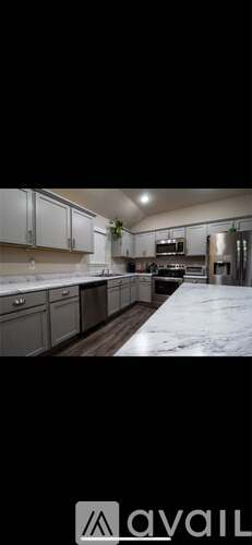 A kitchen with white cabinets and a wooden floor.