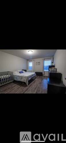 A bedroom with a bed, dresser, and window.