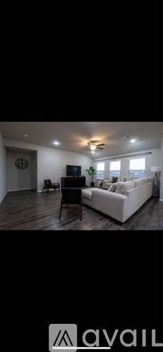 A living room with a white couch and a television.