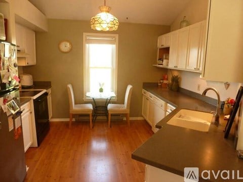 A kitchen with white cabinets and a black countertop.