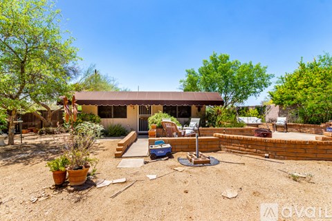 A house with a brown roof and a patio with a brick wall and a fire pit.