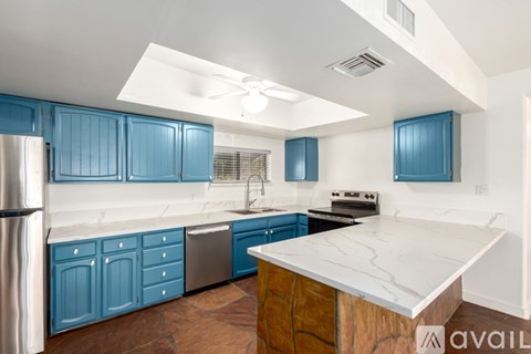 A kitchen with blue cabinets and a marble countertop.