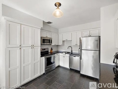 A kitchen with white cabinets and stainless steel appliances.
