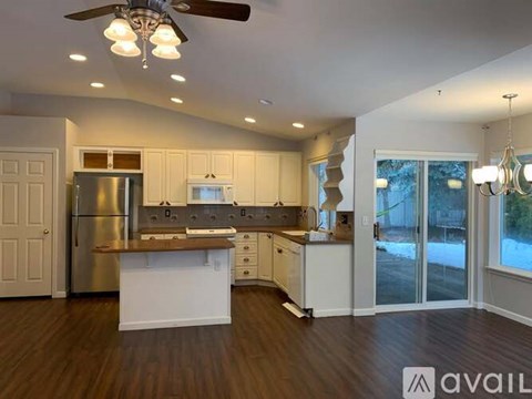 A spacious kitchen with a refrigerator, sink, and cabinets.