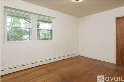 A room with a window and wooden flooring is available for rent.