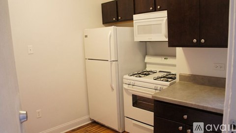 A kitchen with a white refrigerator, white oven, and white stove.