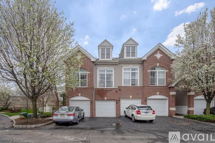 A large brick house with a car parked in front.