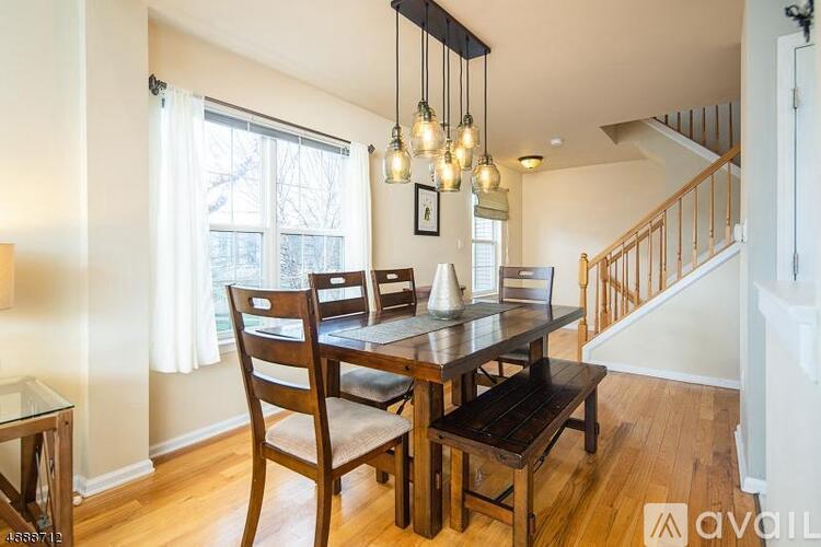 A dining room with a wooden table and chairs.