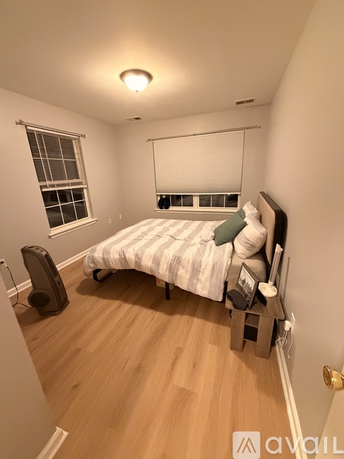 A bedroom with a bed, window, and speaker.