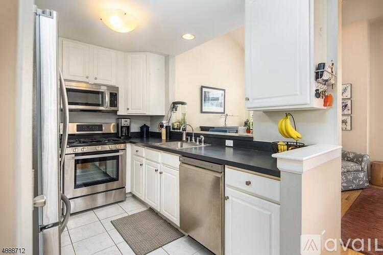 A kitchen with white cabinets and a black countertop.