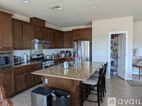 A kitchen with brown cabinets and granite countertops.