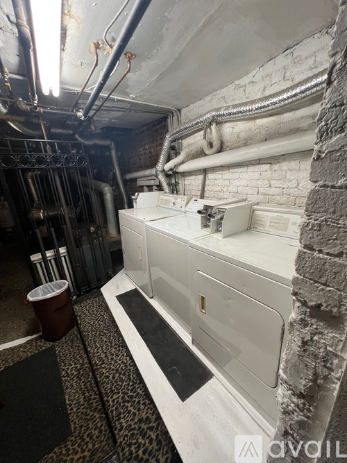 A dirty bathroom with a white sink and a trash can.