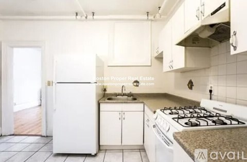 A kitchen with white appliances and cabinets.