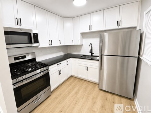 A kitchen with white cabinets and stainless steel appliances.