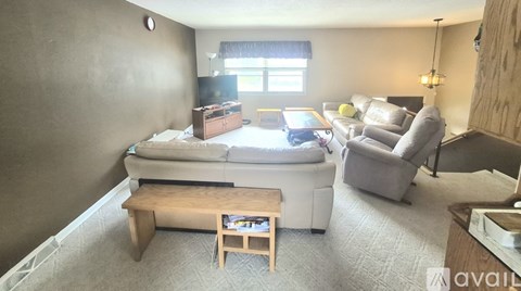 A living room with a couch, a coffee table, and a television.