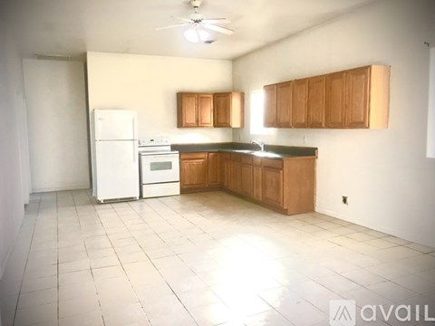 A kitchen with white appliances and wooden cabinets.