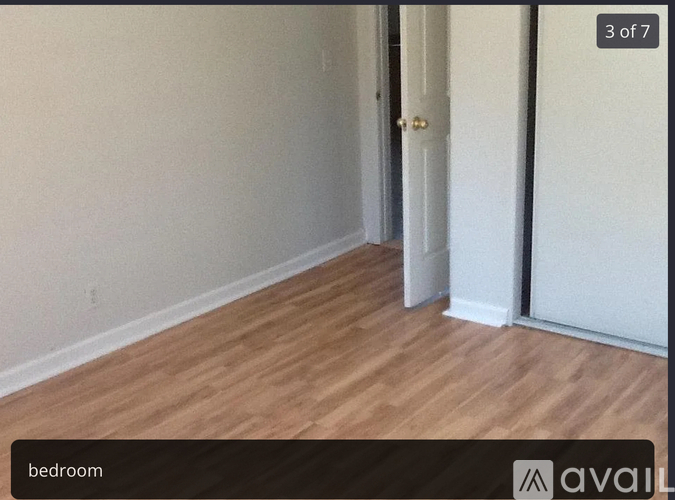 A room with wooden flooring and a white door.