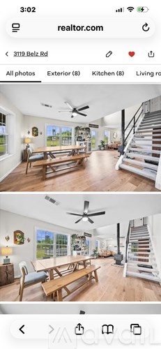 A real estate listing shows a spacious living room with a staircase.