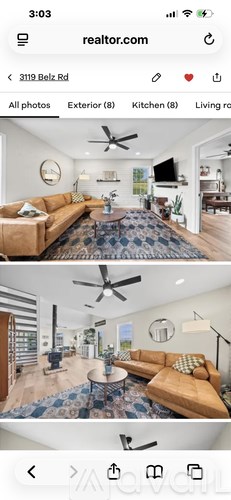 A living room with a brown couch and a blue rug.