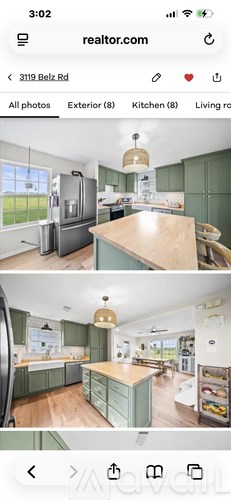 A kitchen with green cabinets and a wooden island.