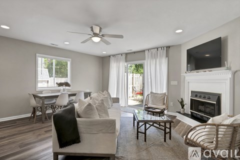 A living room with a fireplace and a television on the wall.