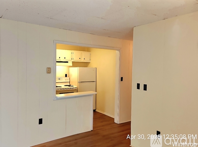 A kitchen with white cabinets and a window is shown in the image.