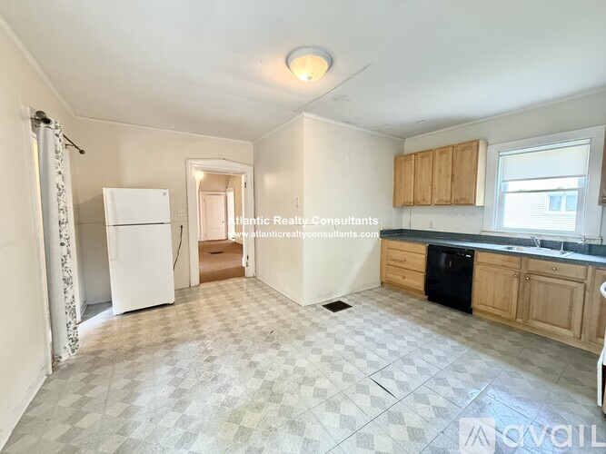 A kitchen with a white fridge, wooden cabinets, and a black dishwasher.