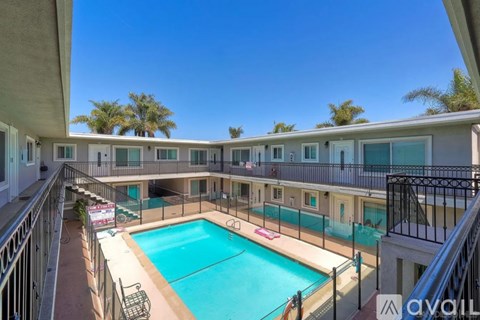 A pool in a courtyard surrounded by balconies.