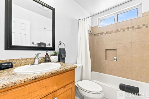 A room with a ceiling fan and a window showing trees outside.