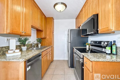 A kitchen with wooden cabinets and granite countertops.