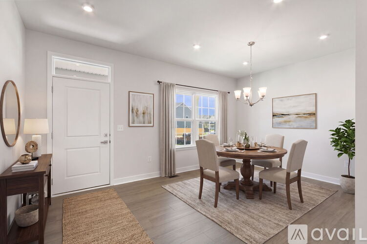 A dining room with a round table and chairs.