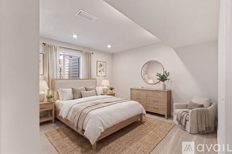A bedroom with a large bed, a chair, and a dresser.