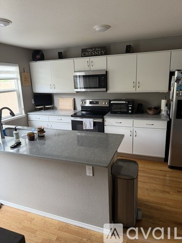 A kitchen with a granite countertop and white cabinets.