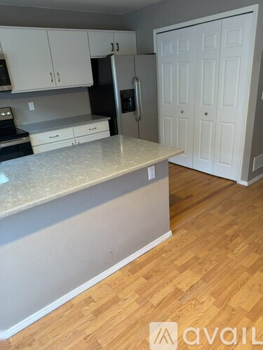 A kitchen with white cabinets and a marble countertop.