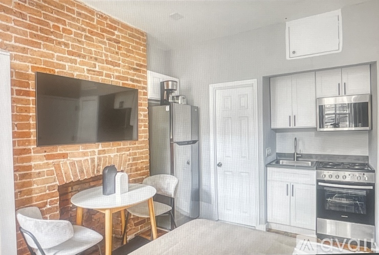 A kitchen with a brick wall and a white fridge.