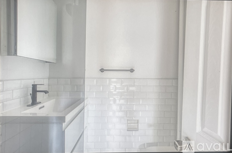 A white bathroom with a sink and a mirror.