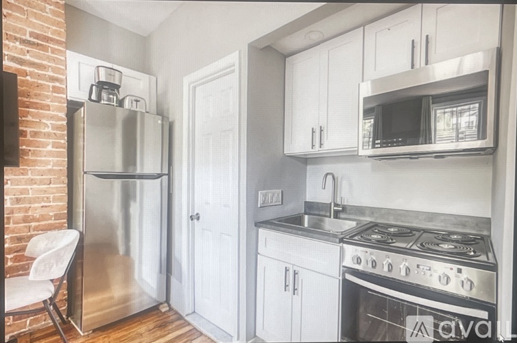 A kitchen with a stove, refrigerator, and microwave.