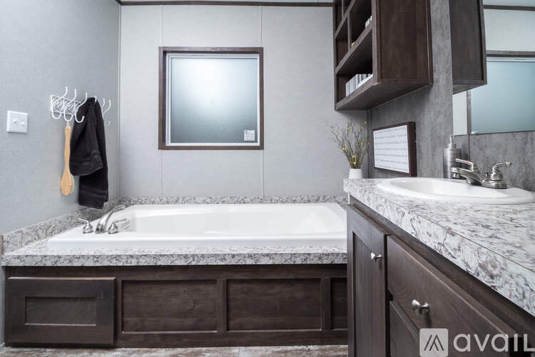 A bathroom with a marble countertop and a wooden cabinet.
