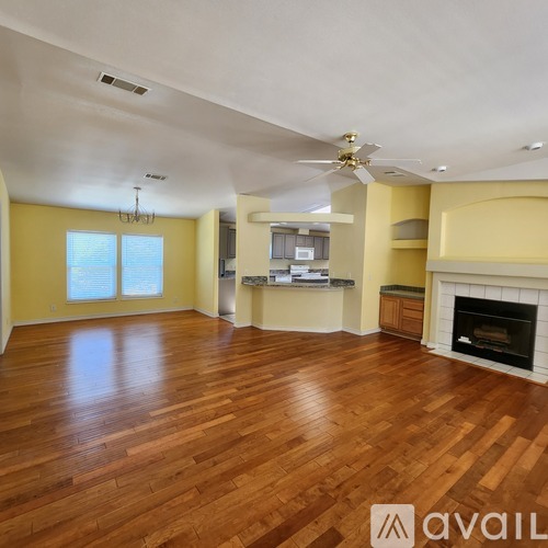 A spacious living room with hardwood floors and a fireplace.