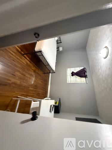 A room with a window and a fan on the table.