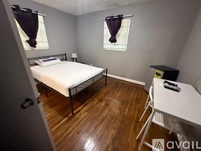 A bedroom with a bed, desk, and chair.