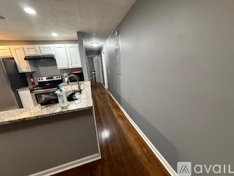 A kitchen with a black stove top oven and white cabinets.