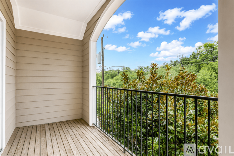 A balcony with a view of trees and sky.