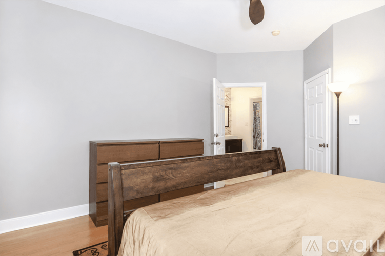 A bedroom with a large bed and a wooden headboard.