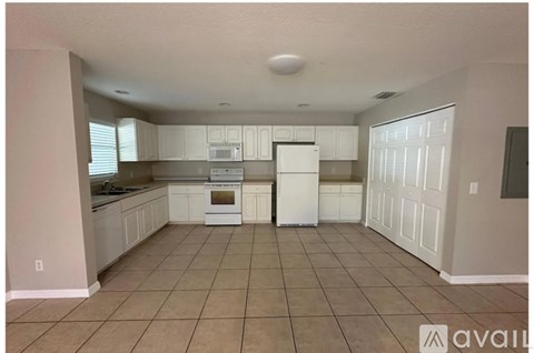 A kitchen with white cabinets and appliances is available for rent.
