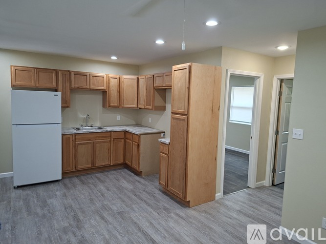A kitchen with wooden cabinets and a white refrigerator.