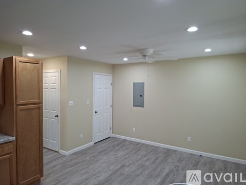 A room with a wooden cabinet and two white doors.