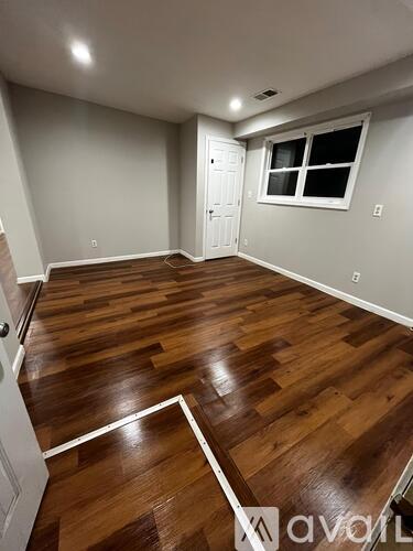 A room with wooden flooring and a window.