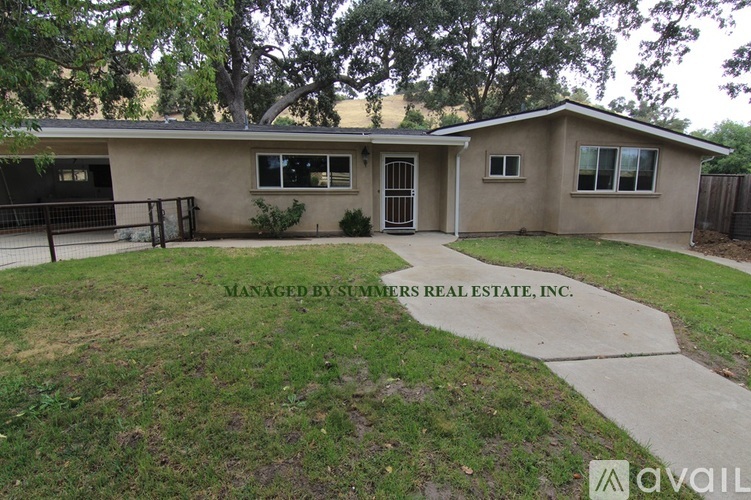A house with a lawn in front and a sign that says "Managed by Summers Real Estate, Inc."
